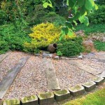садовая дорожка с деревянными элементами в саду